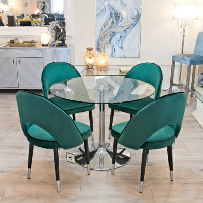 Cassidy green dining chairs around a clear glass dining table